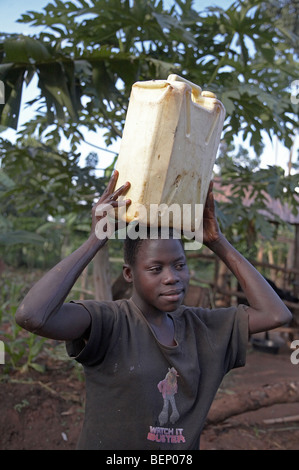 UGANDA im Hause des Najjemba Teopista, Kasaayi Dorf, Kayunga Bezirk. Faustea, 13, Wasser zu tragen. Foto: SEAN SPRAGUE Stockfoto