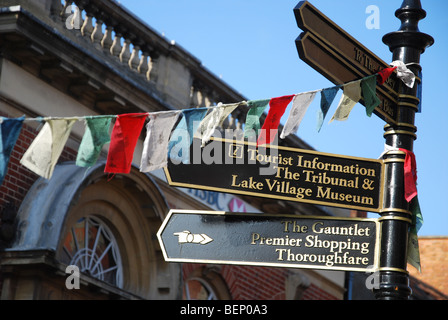 Sign Post und Gebet Flaggen in Glastonbury High Street Somerset England Stockfoto