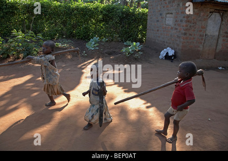 UGANDA im Hause des Najjemba Teopista, Kasaayi Dorf, Kayunga Bezirk. Kevin, Joseph und Maria Werkzeuge, um das Feld zu tragen. Stockfoto