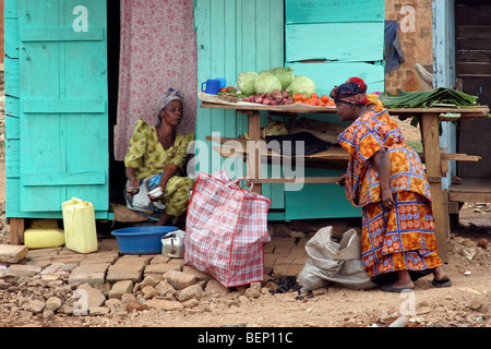 Schwarze Frau kaufen Gemüse aus Straßenhändler in der Stadt Kampala, Uganda, Afrika Stockfoto