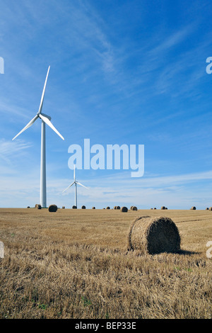 Windkraftanlagen im gemähten Bereich mit Heuballen Stockfoto