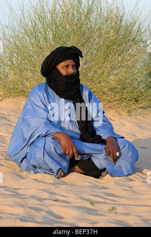 Tuareg / Twareg / Touareg sitzen und tragen Tagelmust / Alasho in Wüste, Timbuktu, Mali, Westafrika Stockfoto