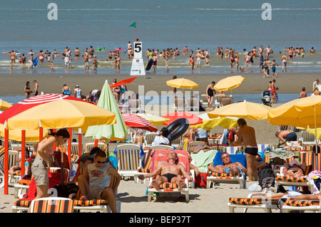 Touristen auf den Liegestühlen Sonnenbaden am Strand während der Sommerferien an der Nordseeküste im Badeort Stockfoto