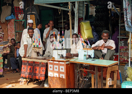 Männer hinter alten Pedal-Nähmaschinen in der Nähwerkstatt in Omdurman, Khartoum, Sudan, Nordafrika Stockfoto