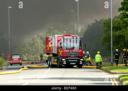 Feuerwehrleute legen hochvolumige Schlauch gegen große chemische Fabrik-Feuer Stockfoto