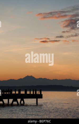 Auf Alki Beach in West Seattle, Washington geht die Sonne über die Olympic Mountains und Bainbridge Island. Stockfoto