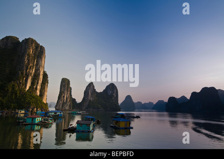 Die schwimmenden Häuser der Fischer, die unter die Karsterscheinungen der Bucht Halong Bucht, Vietnam Leben Stockfoto