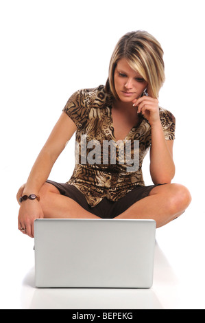 Schöne junge Frau sitzt vor Laptop isoliert auf weißem Hintergrund Stockfoto