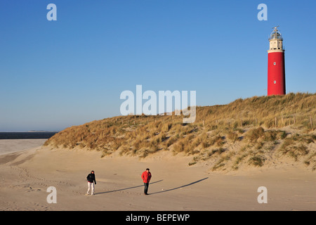 Spaziergänger am Strand und die roten Cocksdorp Leuchtturm Eierland in den Dünen auf der Insel Texel, Niederlande Stockfoto