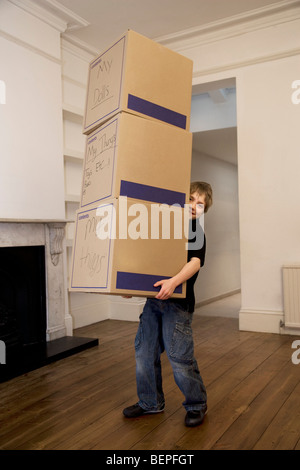 Ein Junge mit einem Stapel von drei Boxen Stockfoto