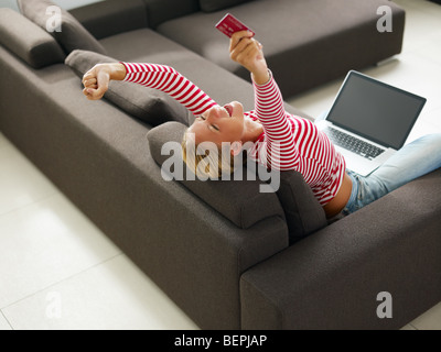 Frau mit Kreditkarte mit erhobenen Armen. Erhöhte Ansicht, Textfreiraum Stockfoto
