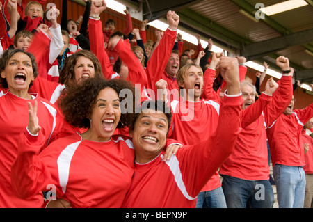 Fans feiern auf bei Fußballspiel Stockfoto