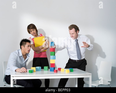 Business-Mann legt letzte Block auf Turm Stockfoto