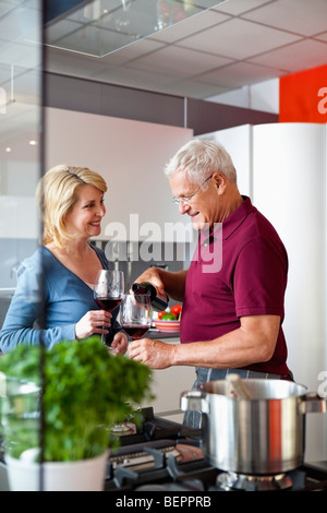 Älteres paar Weintrinken in Küche Stockfoto