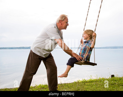 Großvater mit Enkel auf Schaukel Stockfoto