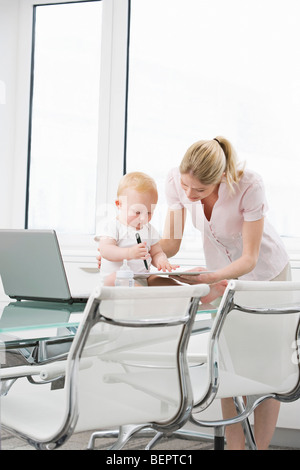 Ein Baby mit einem Kollegen auf einem laptop Stockfoto