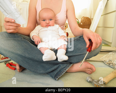 Frau mit Baby-Gebäude-Möbel Stockfoto