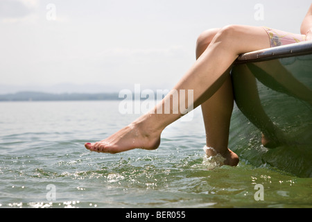 Frau sitzt auf Schiff auf See Stockfoto
