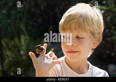 Ein kleiner Junge mit einer Schnecke Stockfoto