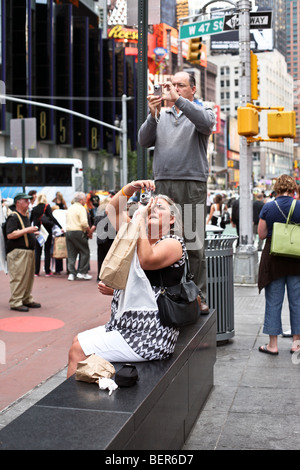 zwei unabhängige mittleren gealterte Hobbyfotografen, ein Mann & eine Frau nehmen gleichzeitig Ziel von Fußgängerzone Wunder vom Times Square Stockfoto