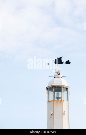Oben ein kleiner Leuchtturm am Peel Harbour auf der Isle Of Man, mit Wikinger-Langschiff Windfahne. Stockfoto