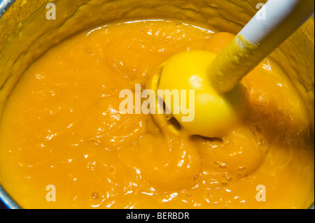 machen Sie heiß Kürbissuppe Topf Mixer pürieren Stamm pürieren belasten Küche Produkte Produktion machen Stabmixer Stockfoto