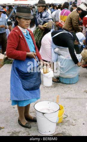 Frau, Verkauf von Getränken aus einem großen Emaille-Eimer zu ihren Füßen.  Ecuador Hochland lokalen Markt. Stockfoto