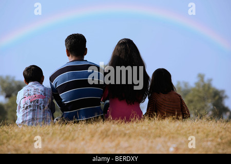 Familie sitzt in einem park Stockfoto