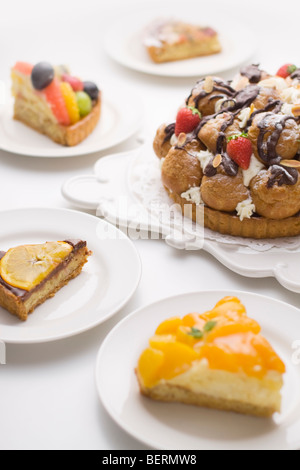 Stücke von Tart um Tart mit windbeutel und Erdbeere, weißer Hintergrund Stockfoto