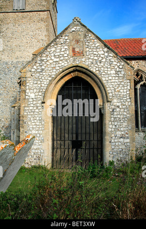 Das Südportal und Turm des stillgelegten Church of Saint Peter am Corpusty, Norfolk, England, Vereinigtes Königreich. Stockfoto