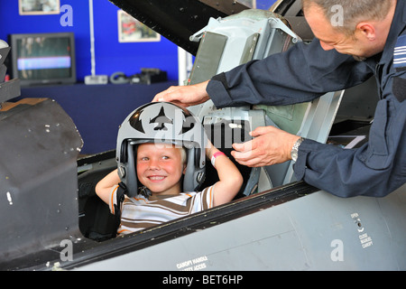 Kind im Cockpit mit Kampfjet-pilot Helm auf Airshow in Koksijde, Belgien Stockfoto