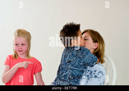 Einzelne Mamma Holding neu angenommenen 3 Jahre alten Hispanic Pflegesohn, während neue Schwester weint Kaukasischen emotionale Emotionen Emotionen HERR © Myrleen Pearson Stockfoto