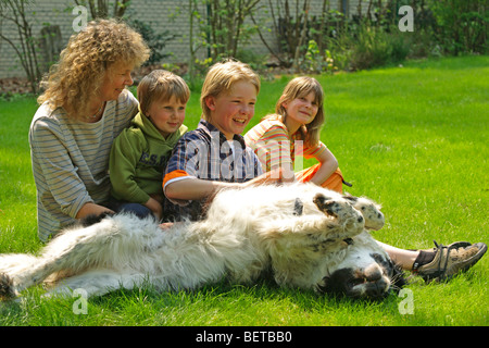 Mutter und Kinder, die ihre Familie Hund in den Garten eingebettet Stockfoto