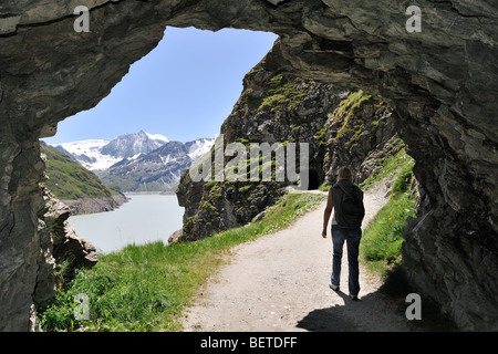 Touristischen Spaziergang durch Höhle entlang des Lac des Dix, gebildet durch den Staudamm Grande Dixence im Wallis / Wallis, Schweizer Alpen, Schweiz Stockfoto