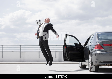 Man spielt Fußball in der Nähe von Auto Stockfoto