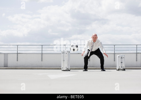 Man spielt Fußball in der Nähe von Auto Stockfoto