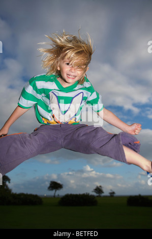 Kleiner Junge in die Luft springen Stockfoto