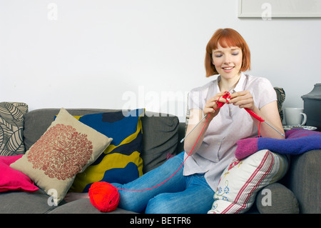 Frau auf Sofa stricken Stockfoto