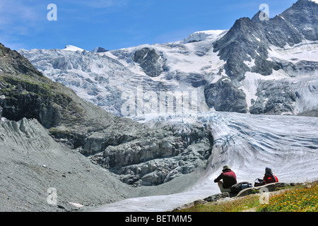 Wanderer / Wanderer ausruhen mit Blick über den Moiry Gletscher in den Walliser Alpen / Walliser Alpen, Valais / Wallis, Schweiz Stockfoto