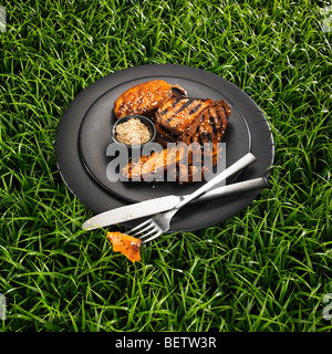 Gegrillte Süßkartoffel mit Sesam auf einer schwarzen Platte und einen Rasen-Hintergrund. Stockfoto