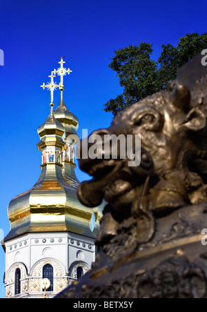 Bronze-Skulptur vor goldenen Kuppeln der Dormition Kathedrale, Höhlenkloster von Kiew, Kiew, Ukraine Stockfoto