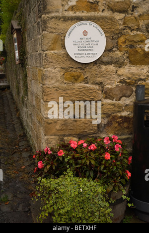 Typische Ferienhäuser in Waddington im Ribble Valley in Lancashire England mit am besten gehüteten Ortsschild Stockfoto