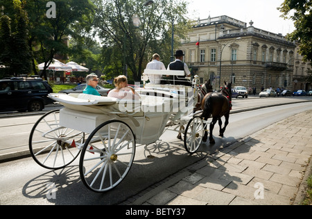 Pferd Kutsche zur Personenbeförderung Touristen rund um Krakau, trabt in der Nähe von The Main Market Square / Markt Platz. Krakau. Polen. Stockfoto