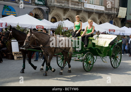 Pferd Kutsche zur Personenbeförderung Touristen rund um Krakau, trabt in den Hauptmarkt / Markt Platz. Krakau. Polen. Stockfoto