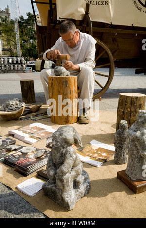 Lokale Künstler, die Herstellung von Skulpturen im Steinsalz aus der Wieliczka Salzbergwerk, an Touristen verkaufen. Marktplatz, Krakau. Polen. Stockfoto