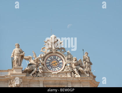 Die reich verzierte Uhr und Statuen auf St. Peter Basilika, Vatikanstadt, Rom, Italien, mit einer halben Mond im Hintergrund Stockfoto