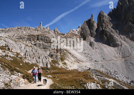 Wanderer und Hund auf einem Pfad unten Paternkofel in den Sextner Dolomiten, Nord-Italien Stockfoto