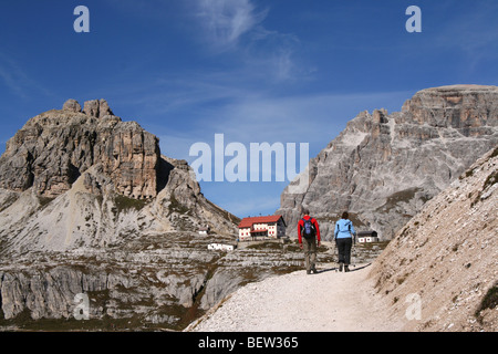 Wanderer auf einem Pfad unten Paternkofel in den Sextner Dolomiten, Nord-Italien - mit Rifugio Locatelli Stockfoto