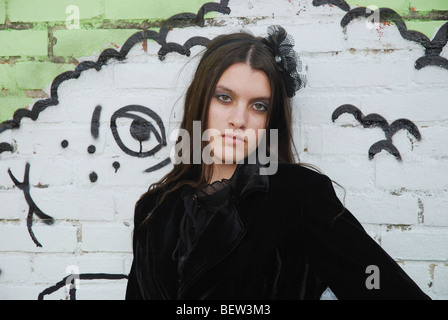 junge Frau posiert vor Graffitiwand Stockfoto