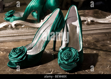 Paar Schuhe's Green elegante Dame auf einem Marmortisch mit einem Spiegelbild. Stockfoto